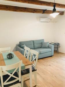 a living room with a blue couch and a table and chairs at Kaala Old House Apartment in Supetarska Draga