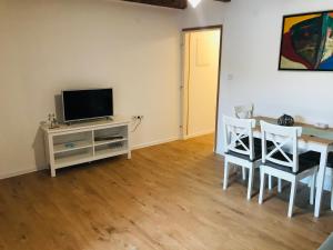 a living room with a television and a table and chairs at Kaala Old House Apartment in Supetarska Draga