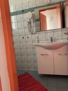 La salle de bains est pourvue d'un lavabo et d'un miroir. dans l'établissement Casa in giardino, à Kalambaka