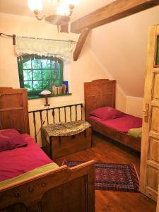 a bedroom with two beds and a window at Domy Konesera in Trzcin
