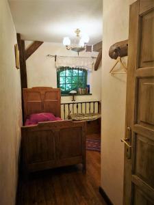 a bedroom with a bed and a window and a door at Domy Konesera in Trzcin