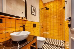 a bathroom with a sink and a toilet and yellow tiles at World House Boutique Hotel Galata in Istanbul