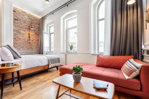 a living room with a red couch and a bed at World House Boutique Hotel Galata in Istanbul