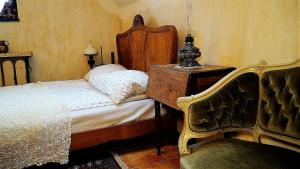 Schlafzimmer mit einem Bett mit einem Kopfteil aus Holz und einem Stuhl in der Unterkunft Domy Konesera in Trzcin