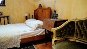 a bedroom with a bed with a wooden headboard and a chair at Domy Konesera in Trzcin