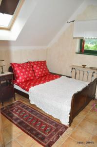 ein Schlafzimmer mit einem Bett und einem roten Sofa in der Unterkunft Domy Konesera in Trzcin