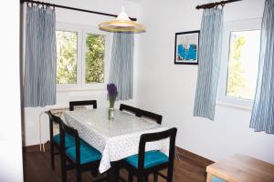 a dining room with a table and chairs and windows at Holiday Home Laurea in Supetar +21 photos