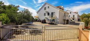 a white house with a gate in front of it at Villa NONO Jure - Private Pool & Jacuzzi, Milna Brač in Milna