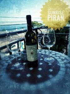eine Flasche Wein auf einem Tisch mit zwei Gläsern in der Unterkunft Apartma Sunrise Piran in Piran