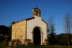 an old church with a cross on top of it at Hotel Casona Cuervo in San Tirso de Candamo