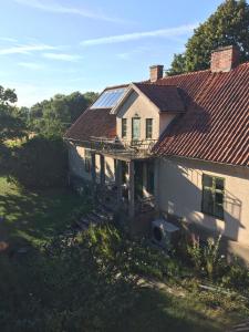 una casa antigua con techo con paneles solares. en Stora Mellings gård en Klintehamn