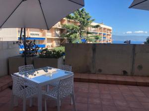 a table and chairs with an umbrella on a patio at Casone Centre-ville, vue mer in Ajaccio