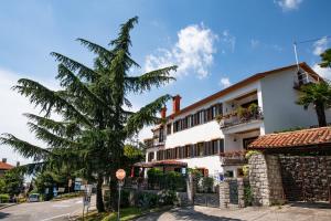 a building with a palm tree next to a street at Apartment Amalia Volosko in Opatija