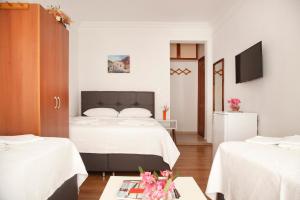 pokój hotelowy z dwoma łóżkami i telewizorem w obiekcie Oğuz Otel Datça w mieście Muğla