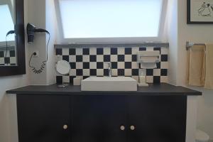 カスカイスにあるApartamento de charmeの洗面台付きのバスルーム、チェッカー付きの壁 +46枚の写真