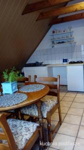 a kitchen with a table and chairs and a kitchen with a counter at Villa Vivaldi in Dziwnówek