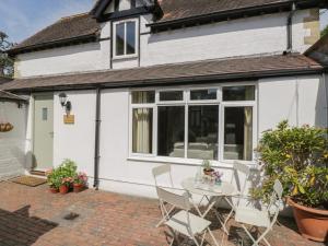 a patio with a table and chairs in front of a house at The Coach House in Stroud