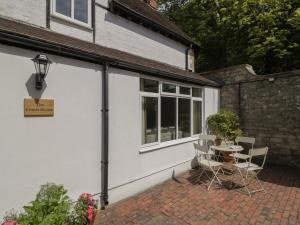 a patio with a table and chairs next to a building at The Coach House in Stroud