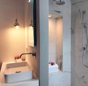 un bagno bianco con lavandino e doccia di Suite Londen66 a Den Bosch Altre 14 foto