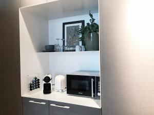 a microwave sitting on a shelf in a kitchen at Suite Londen66 in Den Bosch