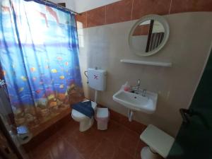a bathroom with a sink and a toilet and a shower curtain at Azalea in Megali Ammos