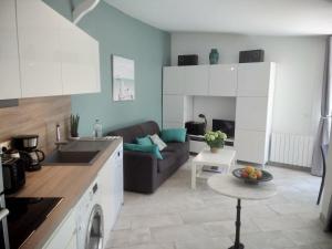 una cucina e un soggiorno con divano e tavolo di Maison Jardin Wifi - Climatisation - 100 m plage sauvage - 20 min Perpignan a Torreilles
