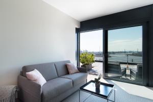 ein Wohnzimmer mit einem Sofa und einem großen Fenster in der Unterkunft The Suites Rainvilleterrasse in Hamburg