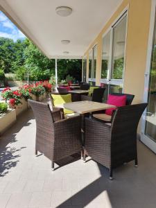 un patio con sillas de mimbre y una mesa de madera. en Hotel Grado, en Bellaria-Igea Marina