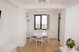 comedor con mesa, sillas y ventana en Mamaia Solid Residence Top Dreams 2, en Mamaia