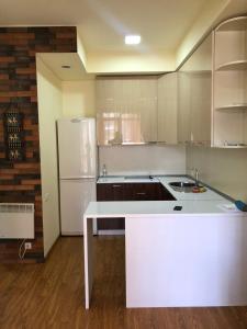 eine Küche mit einer weißen Theke und einem Kühlschrank in der Unterkunft Bel Apart in Dilidschan