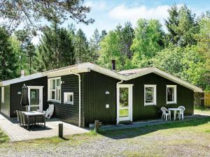 een kleine groene hut met een tafel en stoelen bij Holiday Home Kongeørnen in Odde