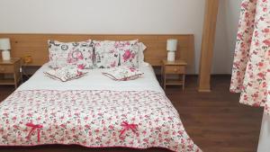 Bett mit roter und weißer Bettwäsche und Kissen in der Unterkunft PENSIUNEA BERCA in Berca