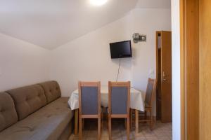 a living room with a couch and a table and chairs at Apartmaji pri Perotu in Izola