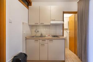 a kitchen with white cabinets and a sink at Apartmaji pri Perotu in Izola