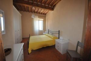 a bedroom with a bed with a yellow bedspread at Casa dei canali, sulla piazza del paese in Capoliveri