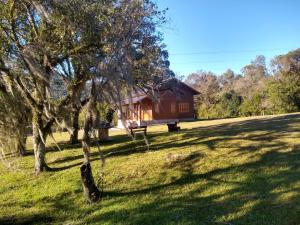 una casa in mezzo a un campo con alberi di CASA TEMPORADA SANTO ANTONIO a Urubici