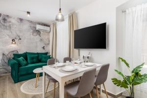 a living room with a table and a green couch at Srnec Apartments - Korzo in Rijeka