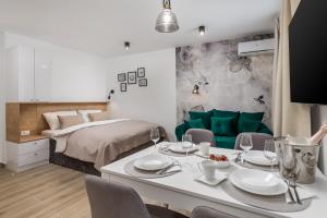 a bedroom with a bed and a table and chairs at Srnec Apartments - Korzo in Rijeka