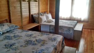 Un dormitorio con dos camas con sábanas azules y blancas. en CASA TEMPORADA SANTO ANTONIO, en Urubici
