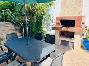 um pátio com uma mesa com um guarda-sol e uma lareira em Au Cœur Des Plages de Rabat em Oulad Kerroum