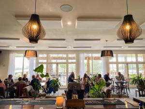 people sitting at tables in a restaurant with large windows at Castaway Norfolk Island in Burnt Pine