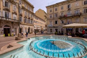 a fountain in the middle of a street with buildings at Srnec Apartments - Korzo in Rijeka