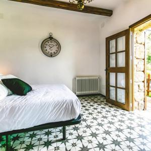 a bedroom with a bed and a clock on the wall at Mas Valoria in Peratallada