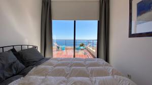 a bedroom with a bed and a view of the ocean at Sea View Apartment Sesimbra- Apartamento Vista Mar in Sesimbra