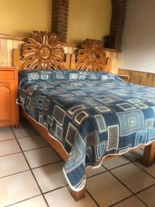 a bedroom with a large bed with a wooden headboard at Habitaciones Betito in Mazamitla