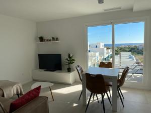 ein weißes Wohnzimmer mit einem Tisch und einem TV in der Unterkunft Playa Flamenca - Turquesa del Mar - great sea view! in Playa Flamenca