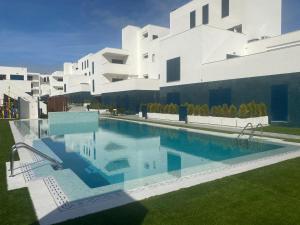 a swimming pool in front of a white building at Playa Flamenca - Turquesa del Mar - great sea view! in Playa Flamenca