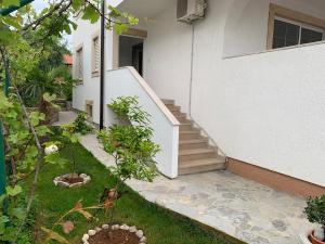 un escalier menant à une maison avec un jardin dans l'établissement Apartman Kartec, à Krk