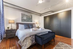 a bedroom with a large bed with a black ottoman at Luxury 1BR OLD CITY-KING BED Walk to Liberty Bell & Independence Mall - FREE PARKING! in Philadelphia