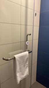 - une serviette blanche suspendue à un porte-serviettes dans la salle de bains dans l'établissement Holiday Inn Express Liaocheng Chiping, an IHG Hotel, à Liaocheng